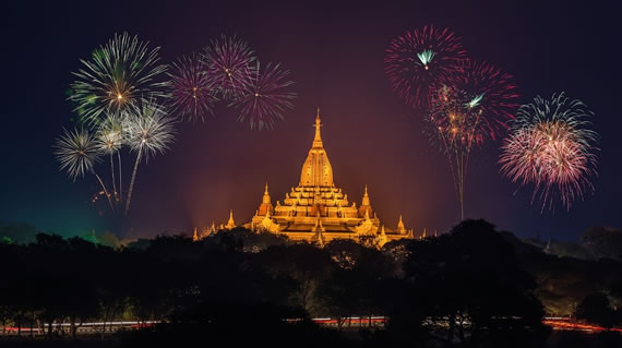 An unforgettable view of a Buddhist stupa with fireworks at dusk